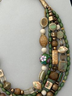 One-of-a-kind multi-strand statement necklace. Handcrafted in Scottsdale, Arizona. Beads: 5 strands of Carved Bone and Jade, Ceramic, Vintage Glass, Wood and Brass. Dimensions: approximately 26" + 3" extender. Make a Statement with this interesting mixture of nature and craftsmanship! Free Shipping Refund Policy Elegant Multi-strand Wooden Beads, Multi-strand Wooden Beads For Jewelry Making, Wooden Multi-strand Beads For Jewelry Making, Green Multi-strand Wooden Beads Jewelry, Artisan Multi-strand Jewelry With Spacer Beads, Multi-strand Necklaces With Spacer Beads For Jewelry Making, Multi-strand Beaded Necklace With Large Beads, Multi-strand Beaded Necklaces, Artisan Double Strand Beads For Jewelry Making