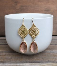 Champagne Chandelier Earrings. These champagne/peach chandelier earrings measure approximately 1-1/2 inches from the top of the diamond-shaped filigree to the bottom of the faceted glass pendant. The ear wires are gold filled, the filigree is gold plated, and the glass pendant is framed in gold plating. Perfect bridesmaid earrings! Your earrings will arrive in a gift box. If this is a gift, I would be happy to include a card with your personal message - just let me know in the message section at Elegant Peach Dangle Earrings, Elegant Apricot Earrings For Gift, Elegant Nickel-free Pink Chandelier Earrings, Elegant Pink Nickel-free Chandelier Earrings, Elegant Apricot Dangle Earrings, Elegant Apricot Dangle Jewelry, Elegant Apricot Jewelry For Wedding, Peach Dangle Earrings For Party, Peach Chandelier