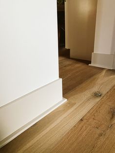 an empty room with white walls and wood floors is seen in this image from the floor to the wall