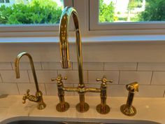 a kitchen sink with two faucets next to a window