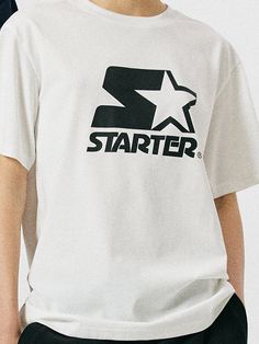 This is a trendy and unique t-shirt by STARTER that is made out of high quality and sturdy material. With distinctive mood of the design and comfortable wear, you can style it for your casual daily outfit.- Woven logo labels detail- Round ribbed neckline- Logo artwork print on the front White Graphic Tee With Star Logo, Casual T-shirt With Star Logo For Streetwear, Summer Streetwear T-shirt With Star Logo, White Short Sleeve T-shirt With Star Logo, Casual Cotton Tops With Star Logo, Graphic Cotton T-shirt With Star Logo, Cotton Graphic Tee With Star Logo, White Star Logo Top For Streetwear, White Tops With Star Logo For Streetwear