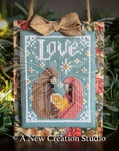 a cross stitch ornament hanging from a tree