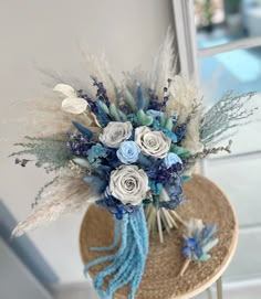 a hat with flowers and feathers on top of a wooden table next to a window