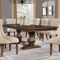 a dining room table with chairs around it and a chandelier hanging from the ceiling