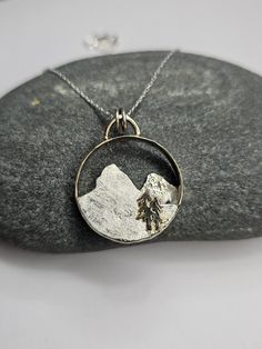 This mountain pendant is handmade from upcycled Yellow Gold and Sterling Silver. The base ring is 14k yellow gold the mountains are Sterling Silver with 18k Yellow Gold and there are 14k yellow Gold trees. I'm an avid hiker and nature inspires me to create jewelry. I'll include a Sterling silver 18 inch necklace. Hammered Yellow Gold Nature-inspired Jewelry, Nature-inspired Jewelry With Large Round Pendant, Nature-inspired Yellow Gold Round Pendant Jewelry, Nature-inspired Hammered Jewelry For Anniversary, Nature-inspired Jewelry With Natural Inclusions In Round Pendant, Nature-inspired Round Pendant Jewelry For Anniversary, Mountain Pendant, Mountain Tree, Organic Textures