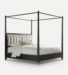 a bed that has a white blanket and pillows on it, with a black frame