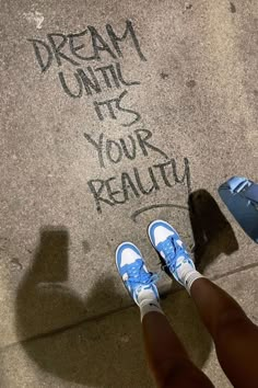 someone's shadow and shoes on the ground with words written in chalk next to them