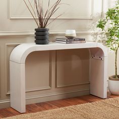 a white console table with a plant on top