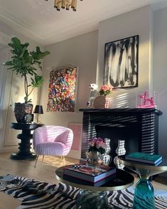 a living room filled with furniture and a painting on the wall above a fire place