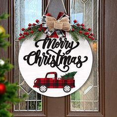 a merry christmas door hanger with a red pickup truck and evergreen wreath on it