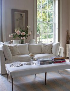 a living room with a white couch and coffee table in front of a large window