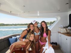 four beautiful women in bikinis posing on a boat