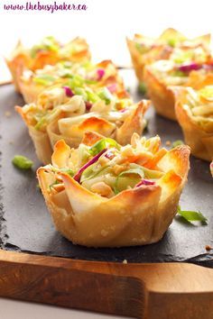 there are many small pastry cups on the tray with text overlay that reads, thai peanut salad wonton cups