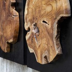 two wooden masks are hanging on the wall next to each other, one is made out of wood