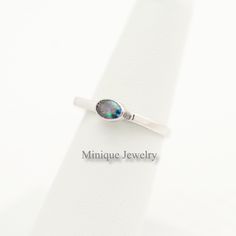 An Oval Shaped Alexandrite Color Changing Gem ring. The minimalist geometric-shaped ring is dainty and it has a simple yet elegant look. Sterling Silver An elegant and minimalist design with an Alexandrite Colored CZ ring. The gem is oval-shaped. We carry the same design with different gemstones also. 🎀 Material: Sterling Silver. 🎀 Dimensions: 🎀The bandwidth: 2 mm 🎀Gemstone: 6 mm X 4 mm 🎀Around 2. 20 grams. 🎀Finish: High polish with Rhodium plating. Please note that this is entirely hand-m Minimalist Oval Cabochon Opal Ring For Anniversary, Minimalist Oval Opal Ring Gift, Minimalist Oval Opal Ring For Gift, Adjustable Oval Opal Ring Minimalist Style, Minimalist Adjustable Oval Opal Ring, Modern Oval Cabochon Opal Ring As Gift, Modern Adjustable Oval Moonstone Ring, Minimalist Sterling Silver Opal Ring Oval, Minimalist Sterling Silver Oval Opal Ring