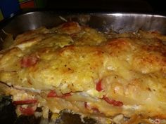 a casserole dish with cheese and tomatoes in a metal pan on the stove