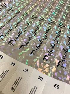 the back side of a sheet of paper with numbers and letters printed on it, all in iridescent colors