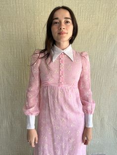 "70s Connie Sage Pink Floral Print Maxi Dress  / Back Zipper/ Waist Tie in Back/ Hook & Eye Closure at Back Neck of Collar / Flocked White Floral Print/ Semi Sheer / Original Buttons at Front and Cuffs Measurements: Size XXS-XS LAID FLAT 100% Cotton Waist: up to 26\" Chest: up to 32\" Shoulder: 12\" Sleeve Length: 25 1/2\" Front Length from HPS: 54\" Condition: Great Vintage Condition PLEASE READ BEFORE PURCHASE :  ALL SALES ARE FINAL" Vintage Mini Dress For Fall, 1970s Style Mini Dress For Spring, Retro Collared Mini Dress For Spring, Pink Retro Dress With Peter Pan Collar, Retro Long Sleeve Day Dresses, Retro Long Sleeve Daywear Dresses, Vintage Collared Party Dress, Vintage Collared Dress For Parties, Spring Mini Dress With Peter Pan Collar