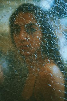 a blurry photo of a woman's face through a glass window with circles on it