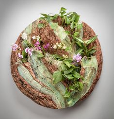 a wooden plate with flowers and leaves on it