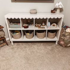 a white shelf filled with baskets and toys