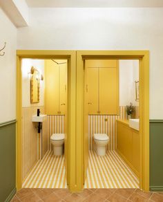 there are two toilets in this bathroom with yellow walls and striped flooring on the wall