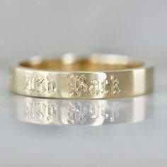 two gold wedding bands with the words you rock engraved on them