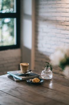 a cup of coffee sitting on top of a wooden table