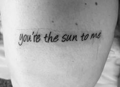 a person with a tattoo saying you're the sun to me