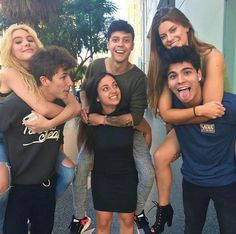 a group of young people standing next to each other in front of a building with their mouths open