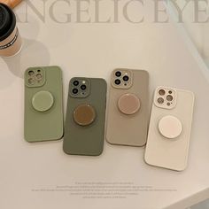 four cell phones are sitting on a table next to a coffee cup and a camera