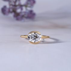 a close up of a ring with a flower in the background