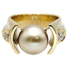 Ring size: 10 Introducing a stunning Cultured Tahitian Pearl & Diamond cocktail ring, a true embodiment of elegance and sophistication. Crafted in 14-karat yellow & white gold, this exquisite piece weighs 22.79 grams, ensuring a substantial and luxurious feel on your finger. The centerpiece of this remarkable ring is a lustrous Tahitian Pearl with a diameter of 11.36 mm. Its deep, dark hue exudes an air of mystery and allure, capturing the essence of the exotic Tahitian waters. On either side of Formal Yellow Gold Pearl Ring With High Luster, Formal High Luster Yellow Gold Pearl Ring, Luxury High Luster Rings For Formal Occasions, Timeless High Luster Rings For Formal Occasions, Formal Yellow Gold Rings With High Luster, High Luster Yellow Gold Rings For Formal Occasions, Formal High Luster Yellow Gold Rings, Formal Yellow Gold Pearl Ring With Brilliant Cut, Wedding Tahitian Pearl Ring In Yellow Gold