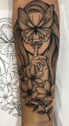 a woman's arm with flowers and a butterfly tattoo on the side of her leg