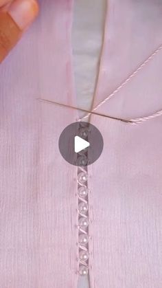 someone is stitching the thread on a pink shirt