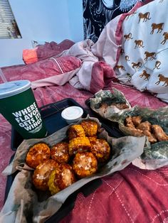 some food is laying out on a bed with a cup and napkins next to it