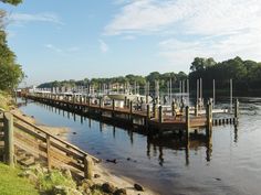 there are many boats docked at the dock on the water's edge in this photo