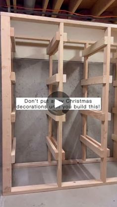 an unfinished room with some wooden shelves in the center and a sign that says don't put a few christmas decorations under it