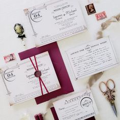 the wedding stationery is laid out on top of each other with scissors and paper