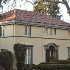 a large house with many windows and bushes