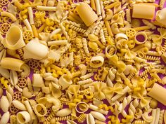 many different types of pasta on a purple surface