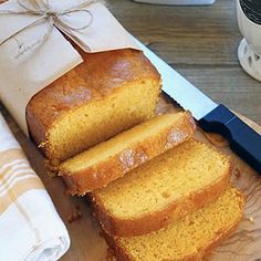 sliced loaf of pound cake sitting on top of a cutting board next to a knife