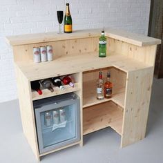 an open cabinet with bottles and glasses on it