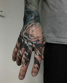 a man's hand with tattoos on it, and his hands are covered in black ink