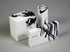 three boxes with black and white designs on them sitting next to each other in front of a gray background