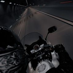 a person riding a motorcycle on a dark road