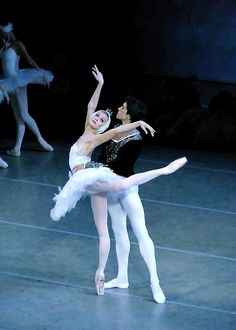 two ballerinas in white tutus and black leotards