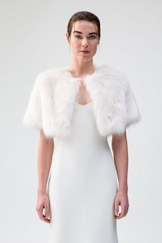 a woman in a white dress and fur stole