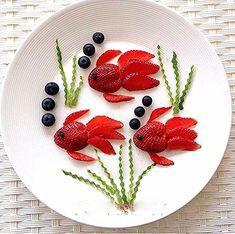 a white plate topped with red fish and blueberries