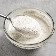 a spoon in a glass bowl filled with yogurt